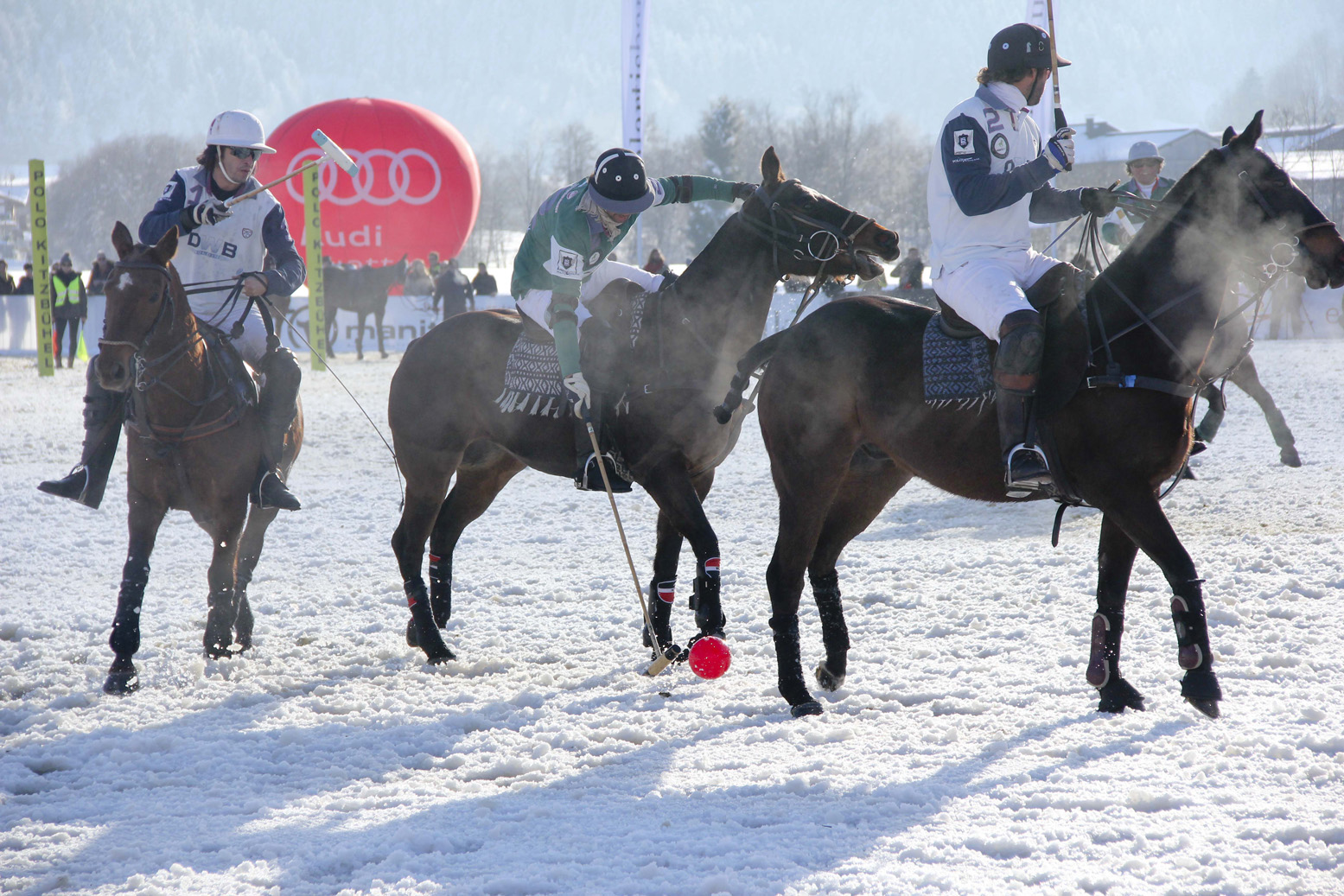 Snow Polo World Cup 2015 mit Polospielern im Schnee und Zuschauern am Spielfeldrand.